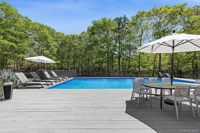 a view of a roof deck with table and chairs under an umbrella