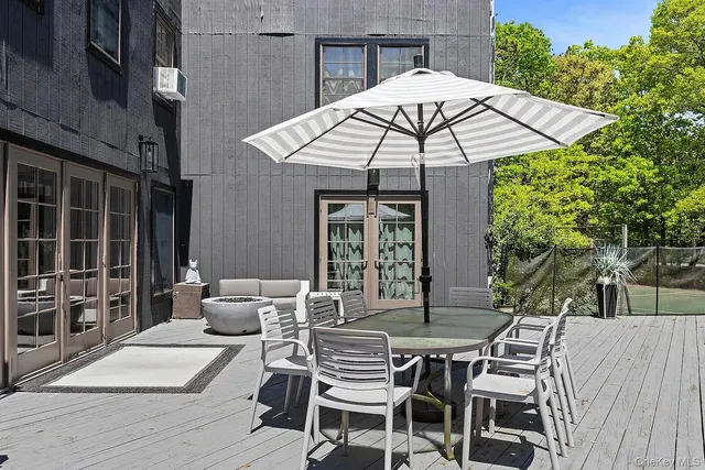 a patio with a table and chairs under an umbrella