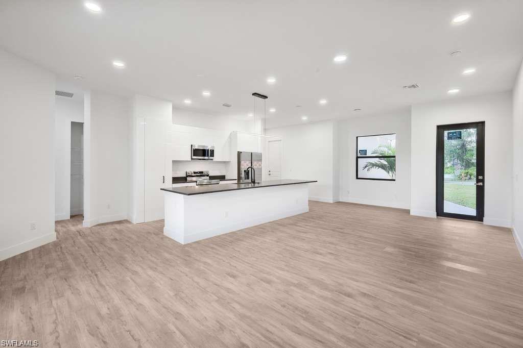 812 Homestead Road South Lehigh Acres, FL 33974 - Photo 21 of 21 a kitchen with stainless steel appliances kitchen island granite countertop a stove a sink and a refrigerator