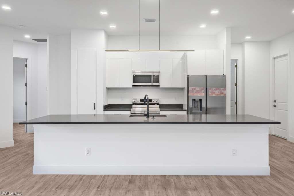 812 Homestead Road South Lehigh Acres, FL 33974 - Photo 4 of 21 a kitchen with stainless steel appliances granite countertop a sink a refrigerator and a stove