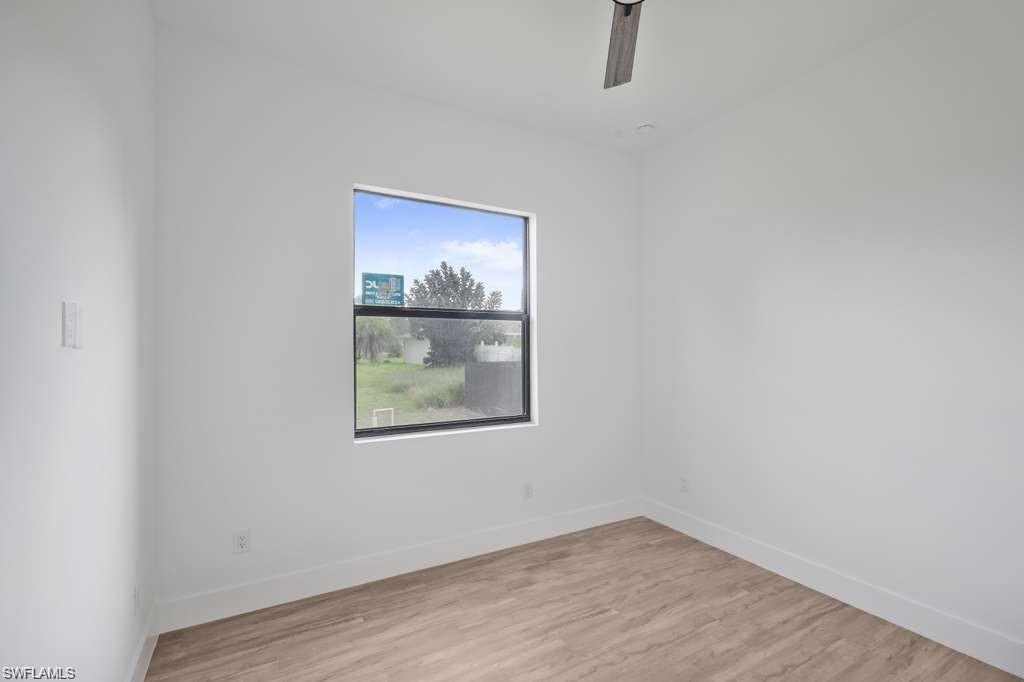 812 Homestead Road South Lehigh Acres, FL 33974 - Photo 7 of 21 a view of an empty room with wooden floor and a window