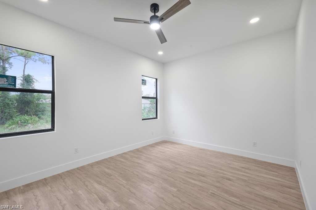 812 Homestead Road South Lehigh Acres, FL 33974 - Photo 8 of 21 an empty room with wooden floor ceiling fan and windows