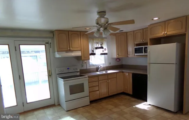 a kitchen with stainless steel appliances granite countertop a refrigerator a sink a stove a microwave and island