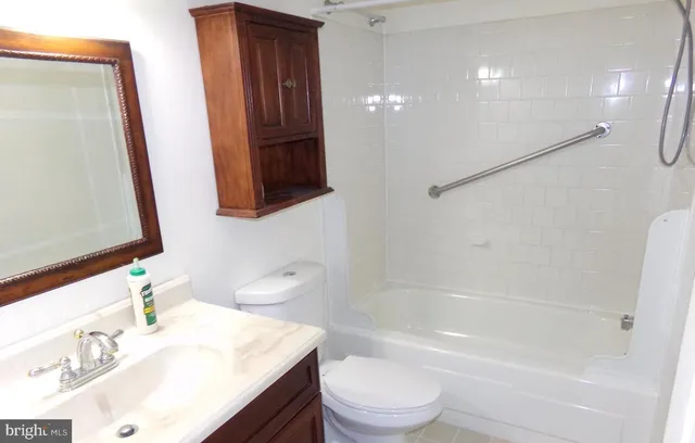 a bathroom with a sink a toilet a mirror and shower