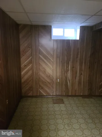 a view of an empty room with wooden floor and entryway