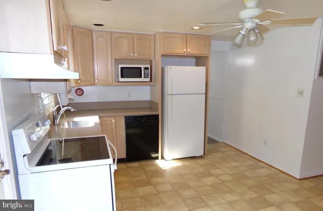 a kitchen with a refrigerator sink and cabinets