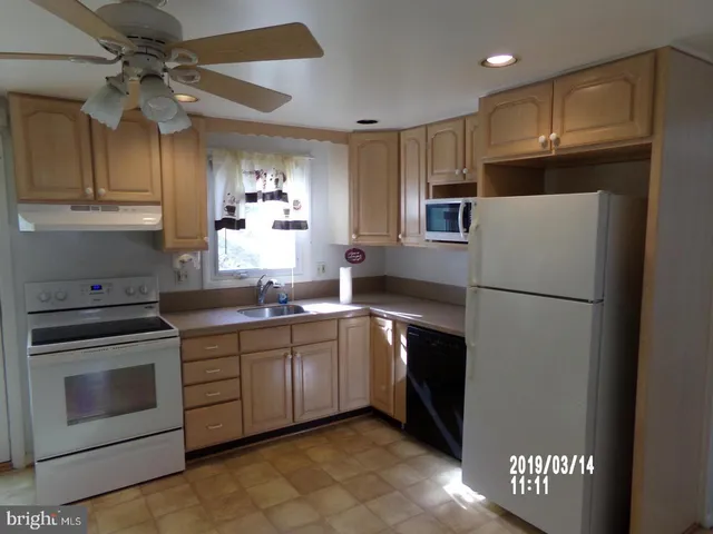 a kitchen with stainless steel appliances granite countertop a refrigerator a sink a stove a microwave and island