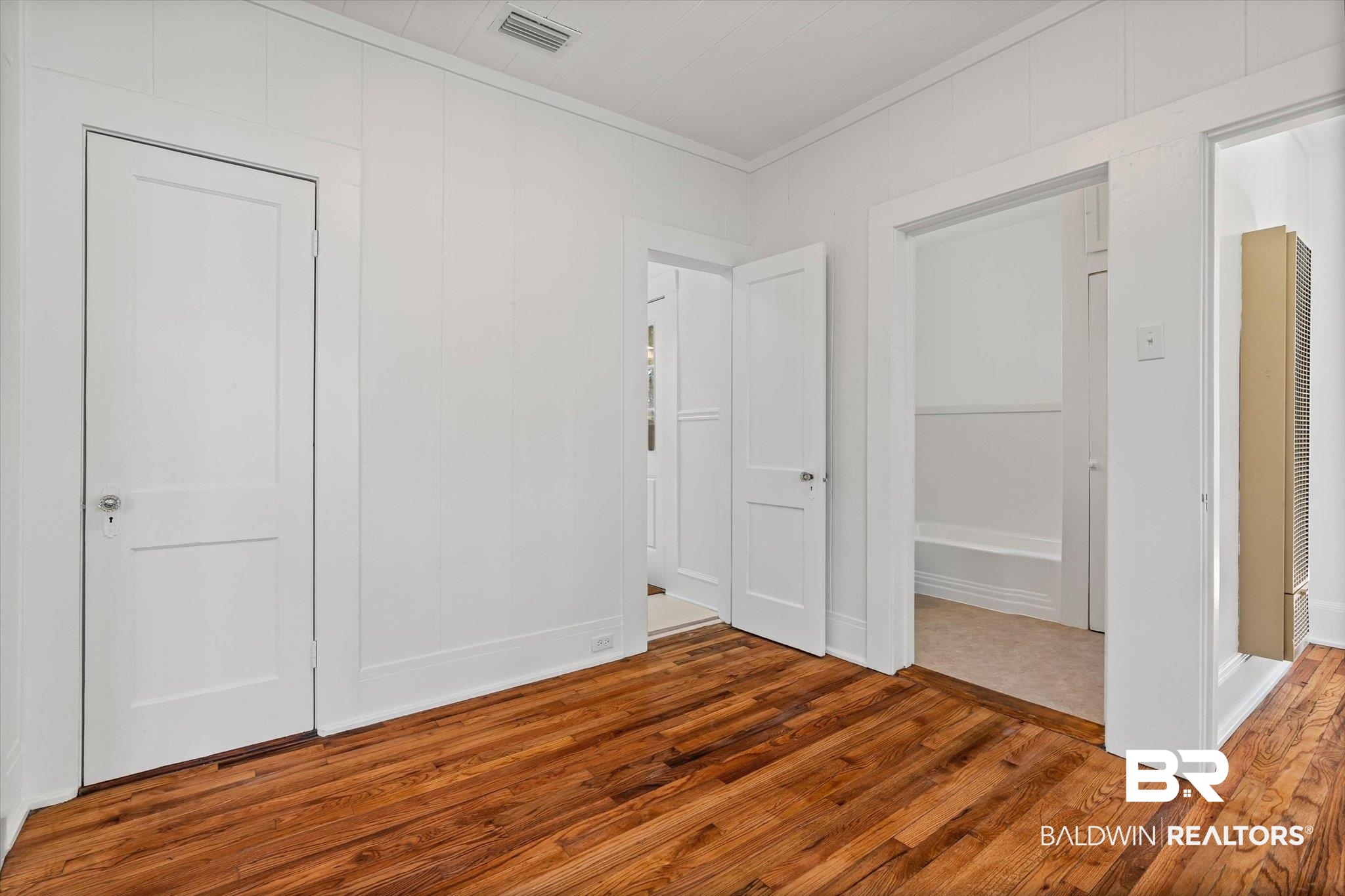 2153 Old Government Street Mobile, AL 36606 - Photo 10 of 23 Unfurnished bedroom with hardwood / wood-style flooring, a heating unit, and crown molding