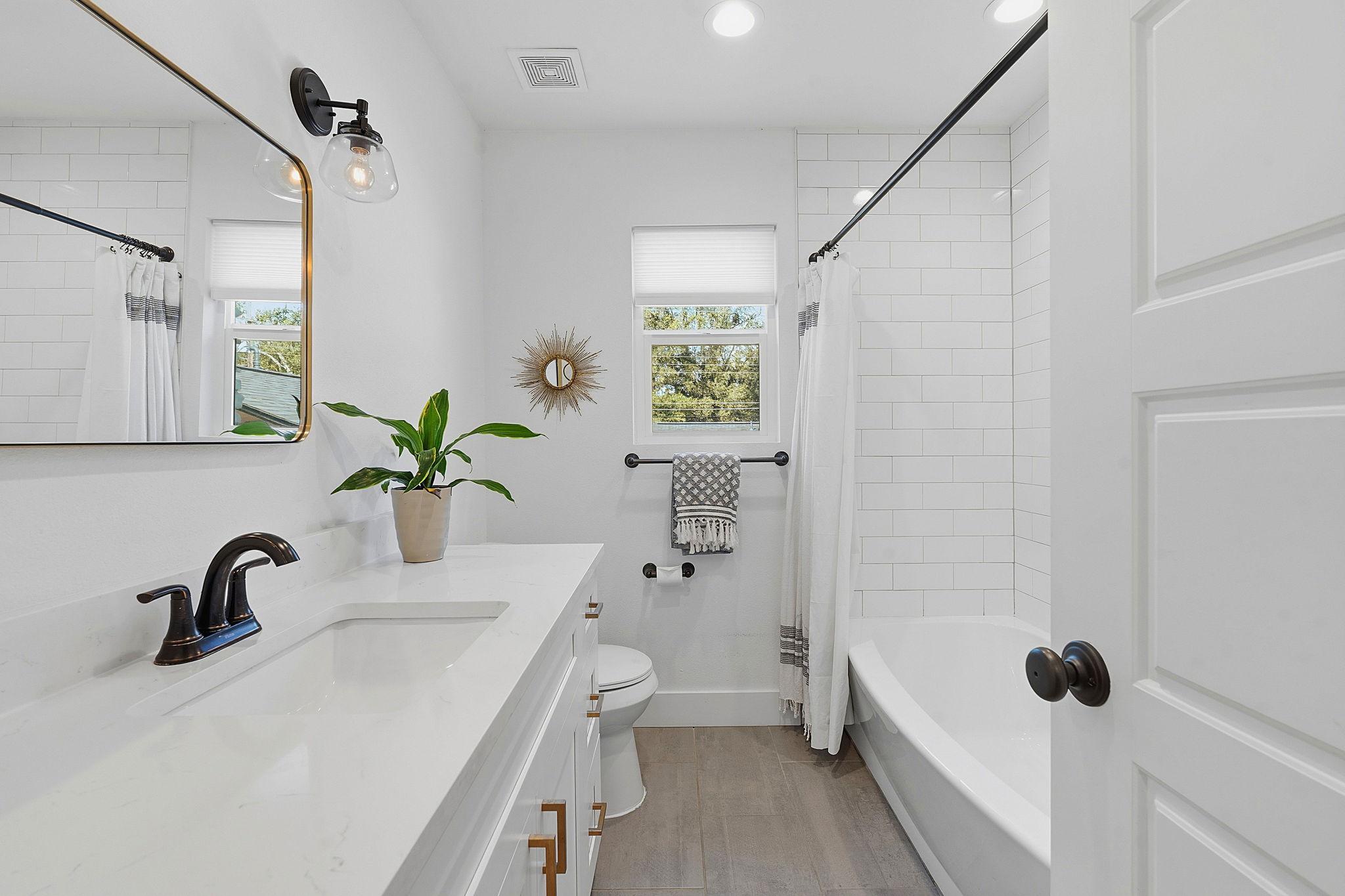 4403 Elmsgrove Drive Austin, TX 78721 - Photo 37 of 38 A well-appointed bathroom with pristine subway tile surrounding a deep soaking tub and an elegant vanity.