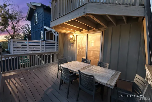 a view of a patio with table and chairs with wooden floor and fence