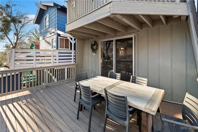 a view of a roof deck with table and chairs with wooden floor and fence