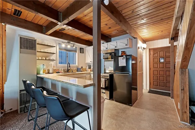 a kitchen with stainless steel appliances kitchen island granite countertop a refrigerator and cabinets