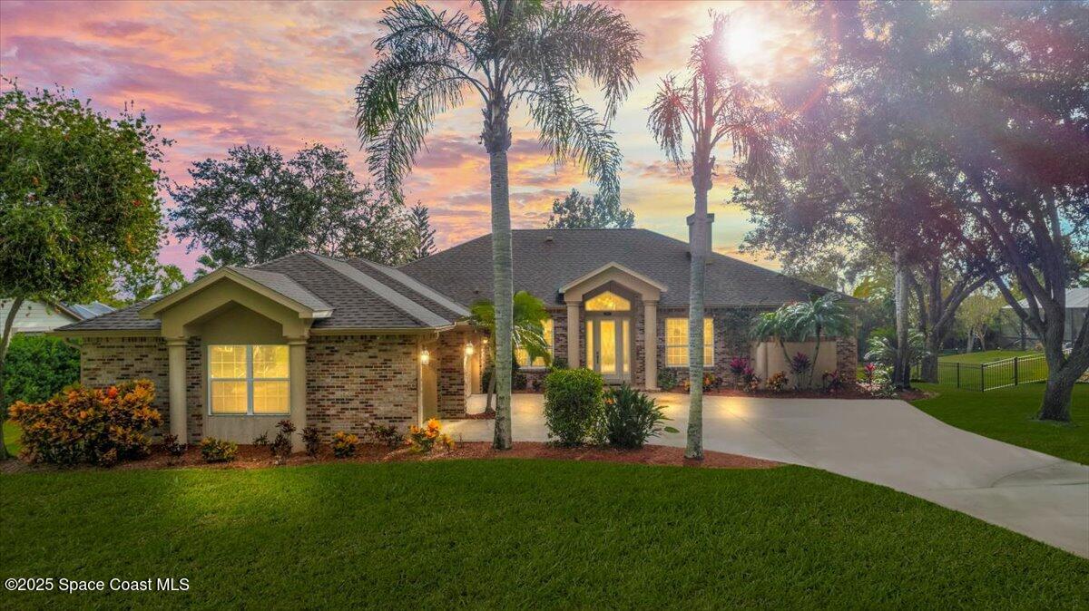 4245 Windover Way Melbourne, FL 32934 - Photo 1 of 50 a front view of a house with a garden and yard