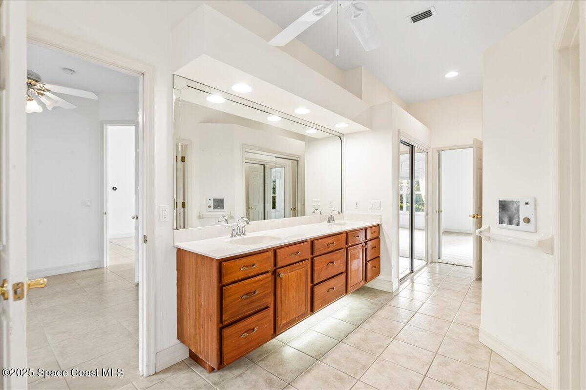 4245 Windover Way Melbourne, FL 32934 - Photo 16 of 50 a large bathroom with a double vanity sink a large mirror and a bathtub
