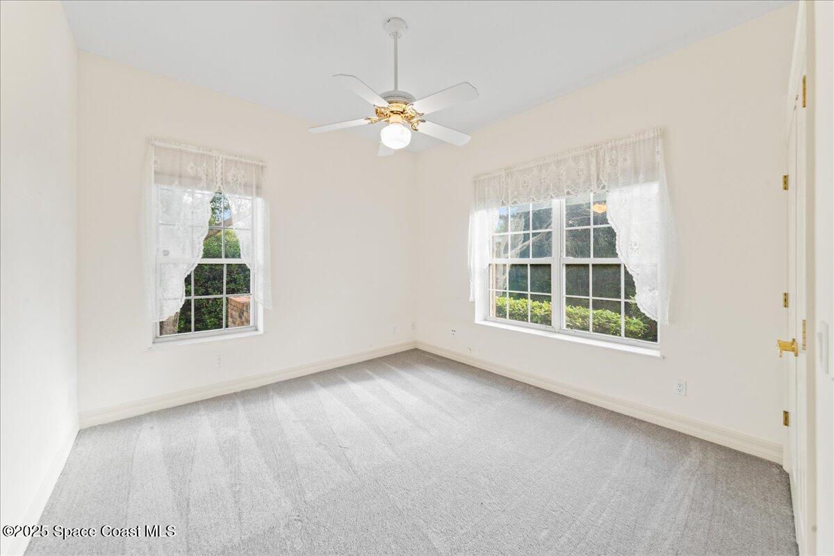 4245 Windover Way Melbourne, FL 32934 - Photo 20 of 50 an empty room with windows and chandelier fan