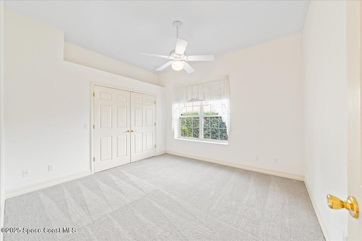 4245 Windover Way Melbourne, FL 32934 - Photo 22 of 50 an empty room with a ceiling fan and a window