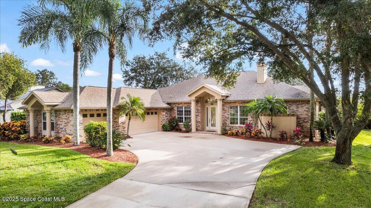 4245 Windover Way Melbourne, FL 32934 - Photo 3 of 50 a front view of a house with garden and trees