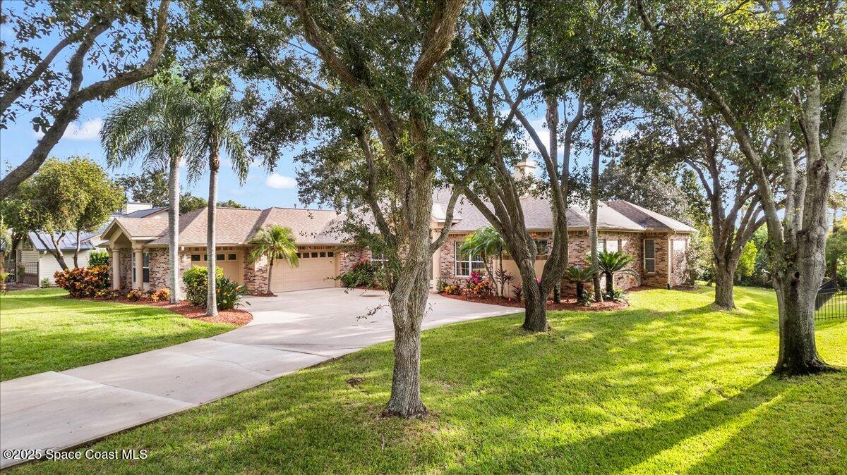 4245 Windover Way Melbourne, FL 32934 - Photo 48 of 50 a view of a house with a big yard and palm trees