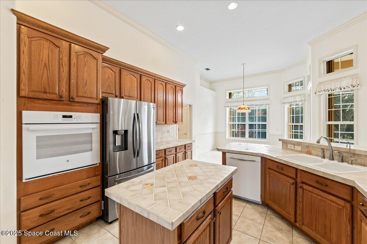 4245 Windover Way Melbourne, FL 32934 - Photo 7 of 50 a kitchen with a refrigerator a sink and wooden cabinets
