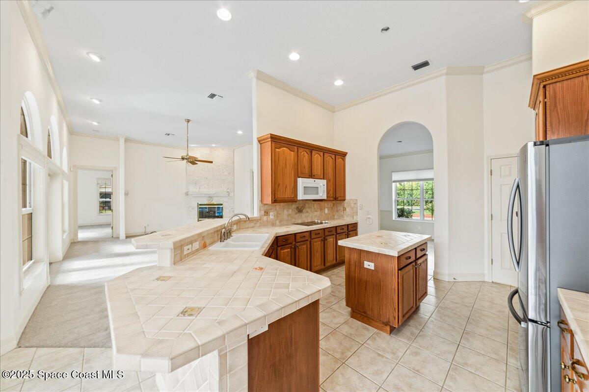 4245 Windover Way Melbourne, FL 32934 - Photo 9 of 50 a kitchen with granite countertop a refrigerator and a sink
