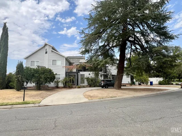 a front view of a house with a yard and trees