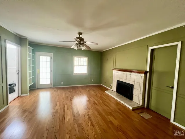 a view of an empty room with window and wooden floor