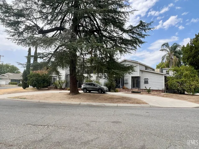 a view of a house with a tree in front of it