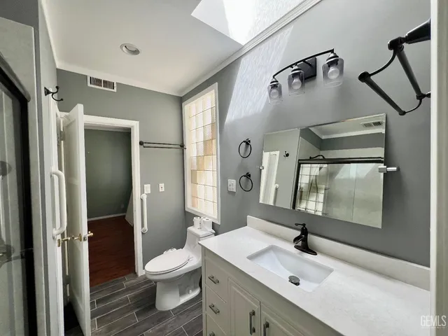 a bathroom with a granite countertop sink toilet and shower