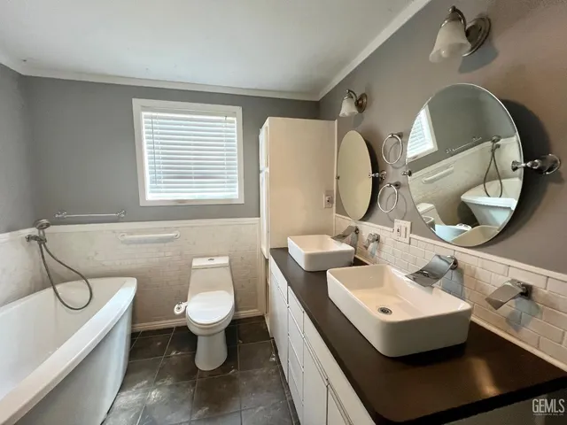 a bathroom with a toilet sink and mirror