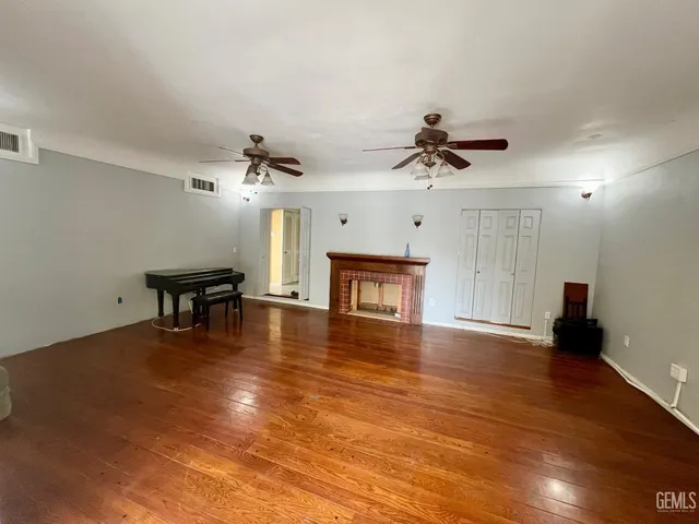 a view of a livingroom with a hardwood floor and a ceiling fan