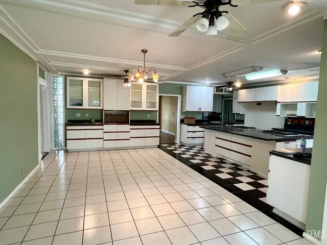 a kitchen with stainless steel appliances kitchen island granite countertop a refrigerator and a stove top oven