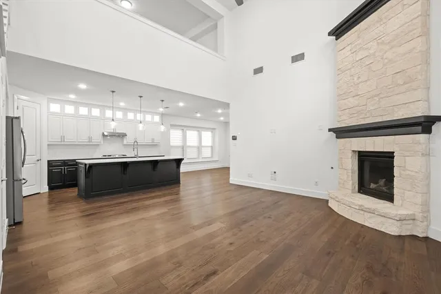 a large white kitchen with a sink and a fireplace