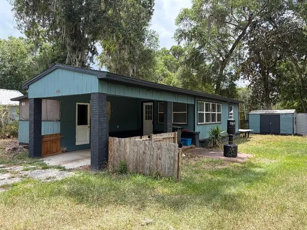 a view of a house with backyard and a tree