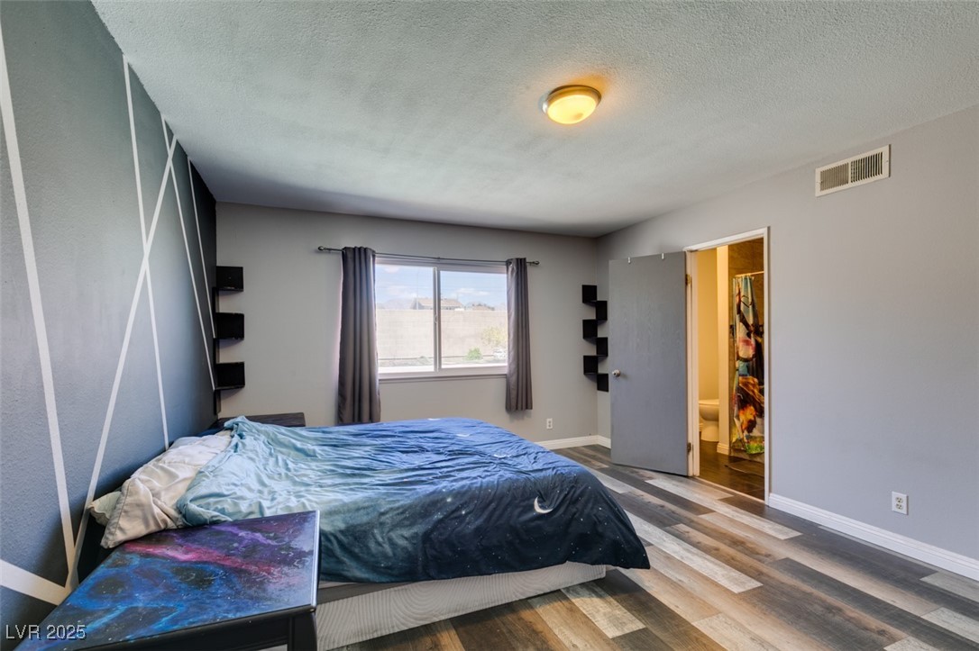 100 Huntly Road Las Vegas, NV 89145 - Photo 10 of 16 Bedroom featuring wood finished floors, baseboards, and a textured ceiling