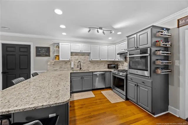 a kitchen with stainless steel appliances granite countertop a refrigerator oven a sink and dishwasher