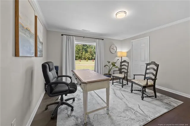 a view of a workspace with furniture and a window