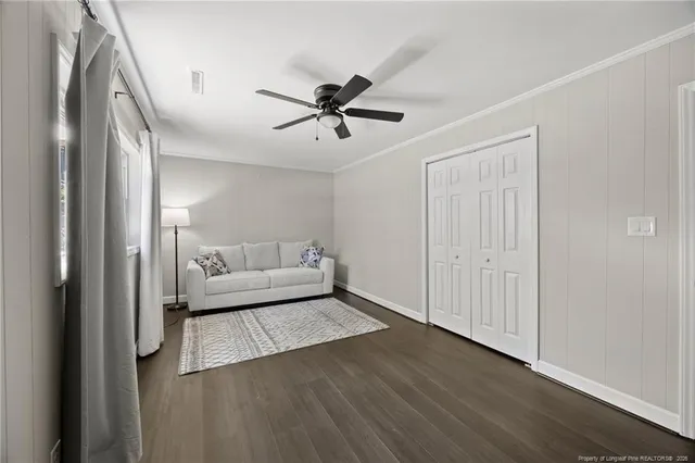 a view of a livingroom with a ceiling fan and wooden floor