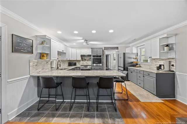 a kitchen with kitchen island granite countertop lots of counter top space and stainless steel appliances