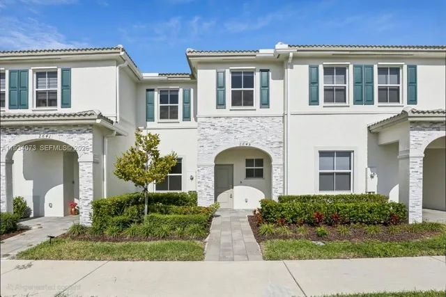 a front view of a brick house with a yard