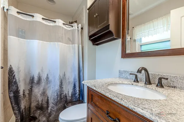 a bathroom with a granite countertop sink toilet and shower