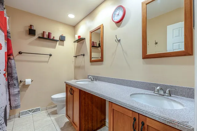a bathroom with a granite countertop sink a mirror and a toilet