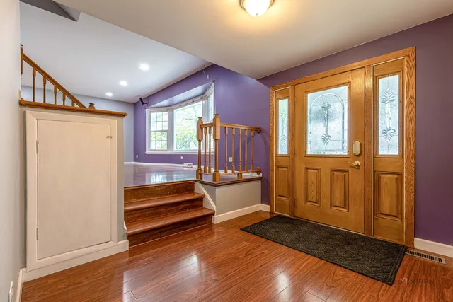 a view of front door with wooden floor and furniture