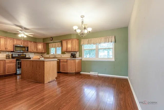 a kitchen with wooden floors and white cabinets
