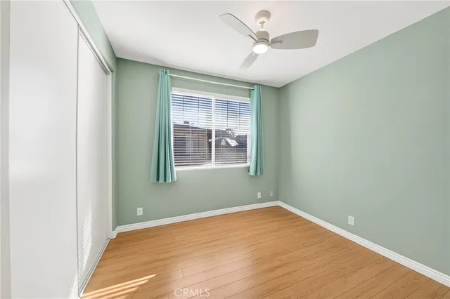an empty room with a window and ceiling fan