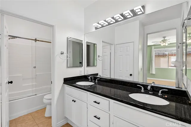 a bathroom with a granite countertop sink a mirror and a shower