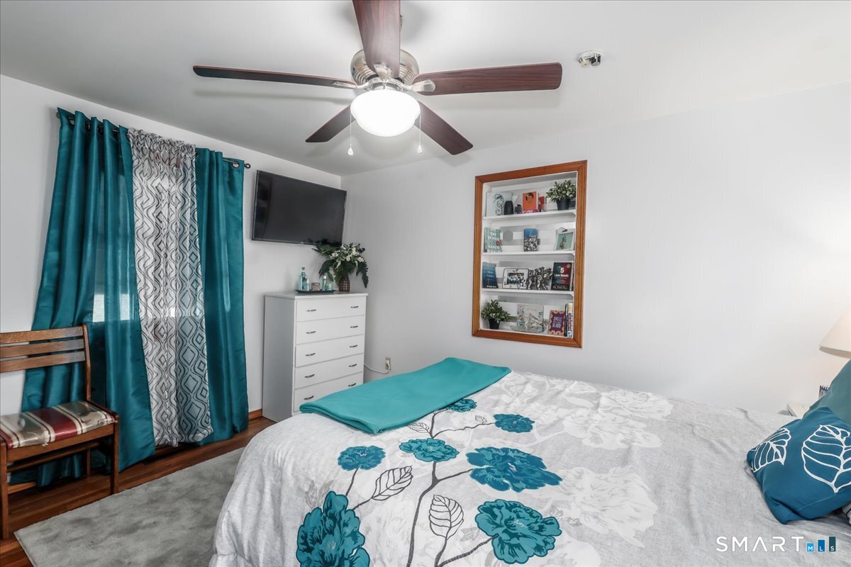 306 Welton Street Hamden, CT 06517 - Photo 15 of 38 a bedroom with a large bed and a chandelier