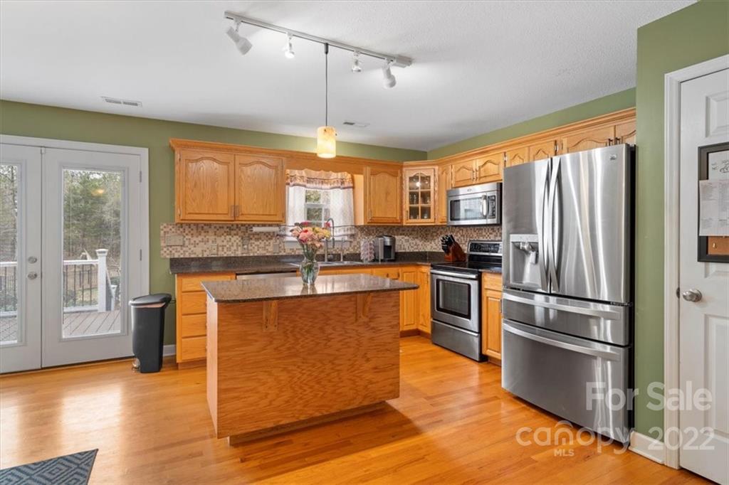 1574 Dirt Road Lancaster, SC 29720 - Photo 10 of 36 a kitchen with stainless steel appliances granite countertop a refrigerator a stove and a wooden floors