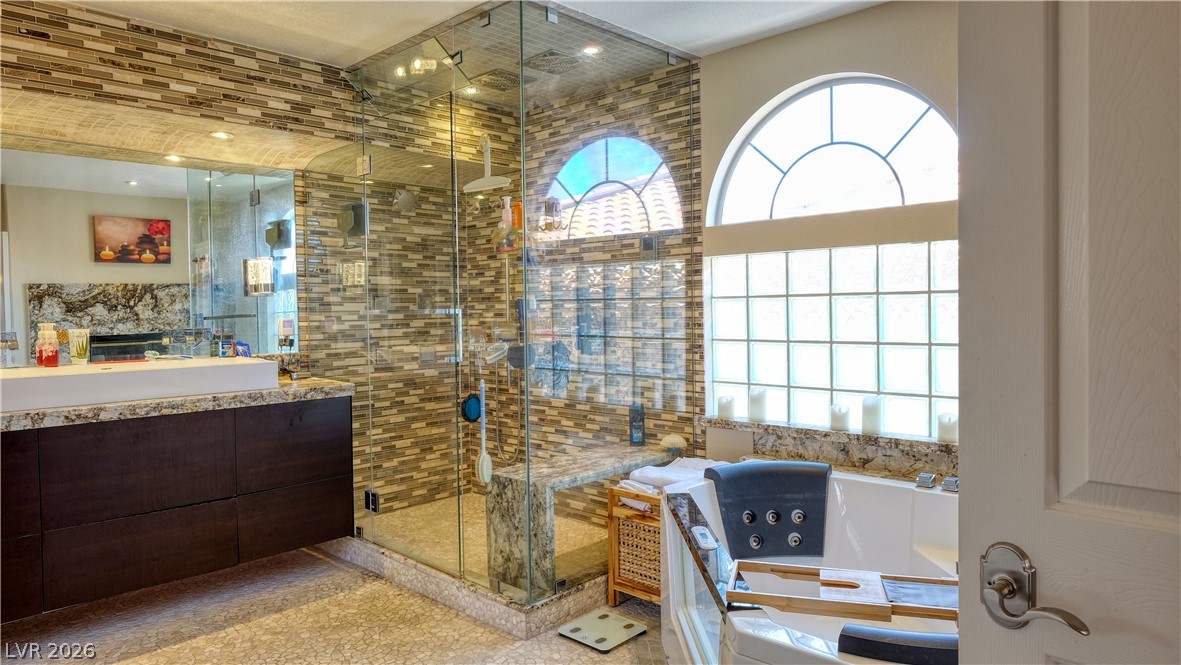 3704 North Campbell Road Las Vegas, NV 89129 - Photo 34 of 38 Indulge in a spa-like retreat with this well-appointed bathroom featuring an expansive glass-enclosed shower and a luxurious soaking tub.