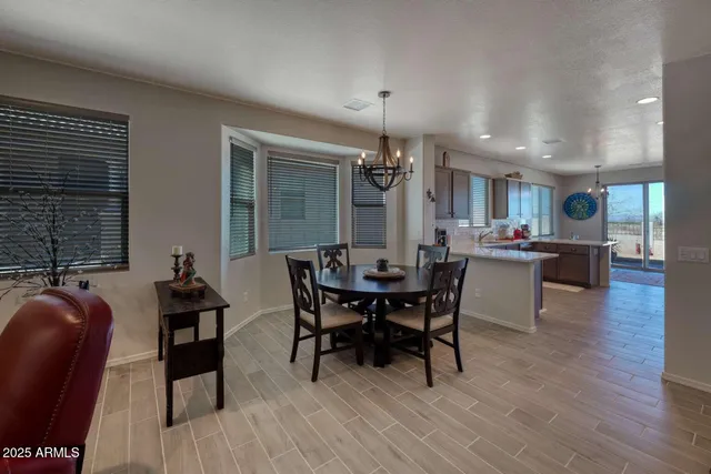 a kitchen with stainless steel appliances granite countertop wooden cabinets a refrigerator a sink a stove a refrigerator and island with wooden floor