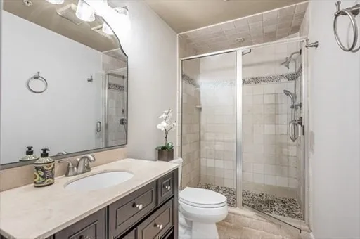 a bathroom with a shower sink vanity mirror and toilet